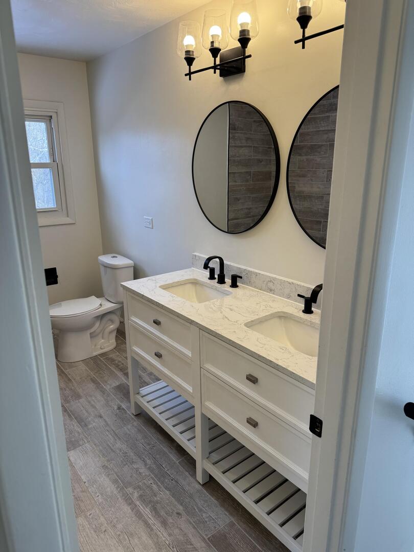 2452 Florian Court Decatur, IL 62526 - Photo 16 of 28 a bathroom with a granite countertop toilet sink and mirror