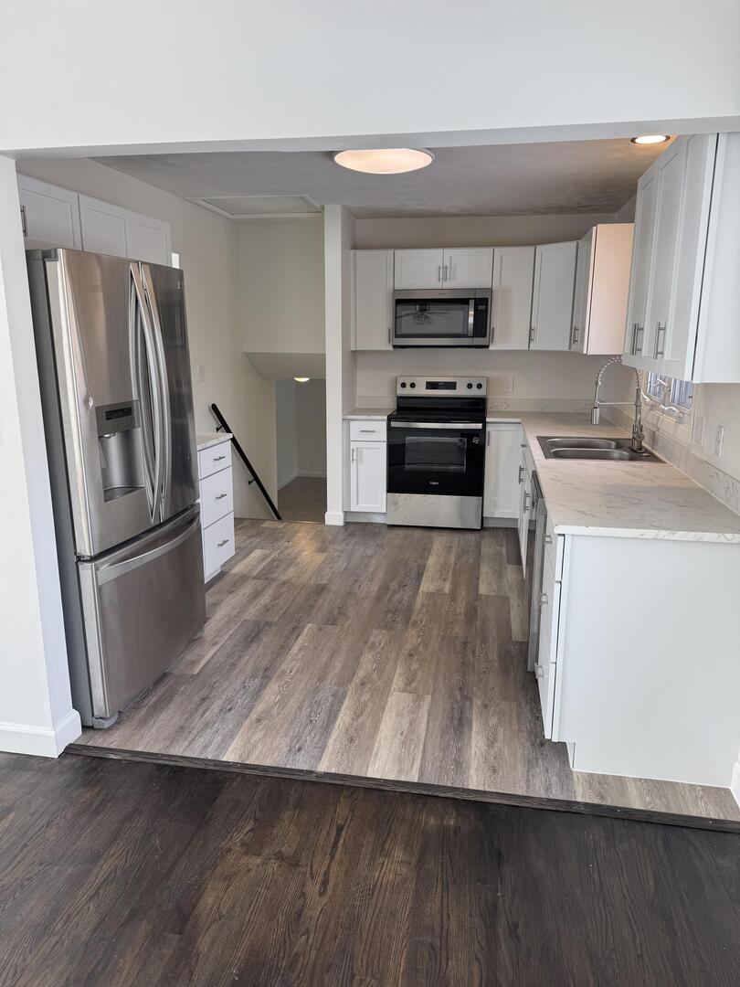 2452 Florian Court Decatur, IL 62526 - Photo 6 of 28 a kitchen with wooden floors and refrigerator