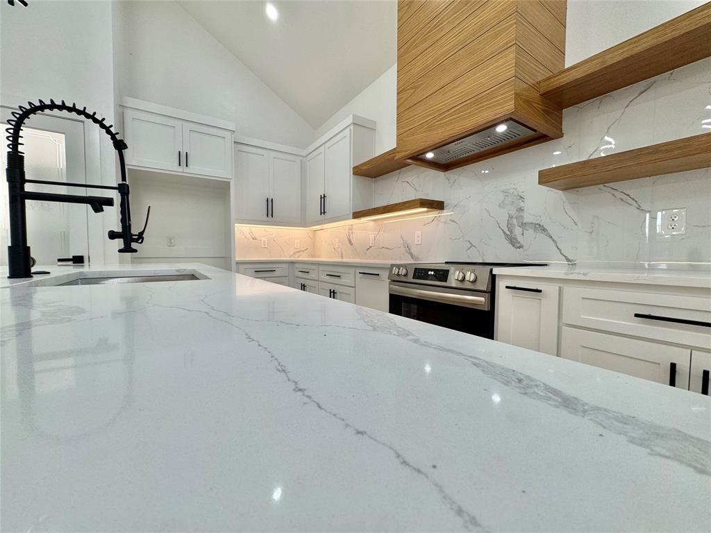 2125 Rs County Road 3150 Emory, TX 75440 - Photo 32 of 40 a kitchen with stainless steel appliances granite countertop a stove a sink and white cabinets