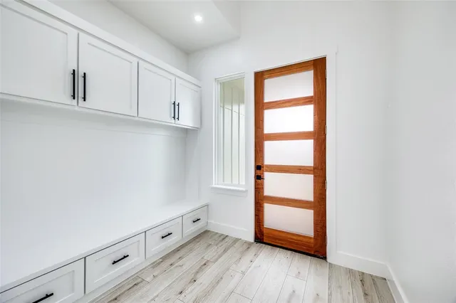 a view of an empty room with wooden floor and closet