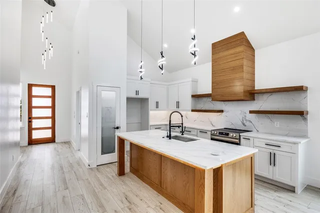 a kitchen that has a lot of cabinets and wooden floor