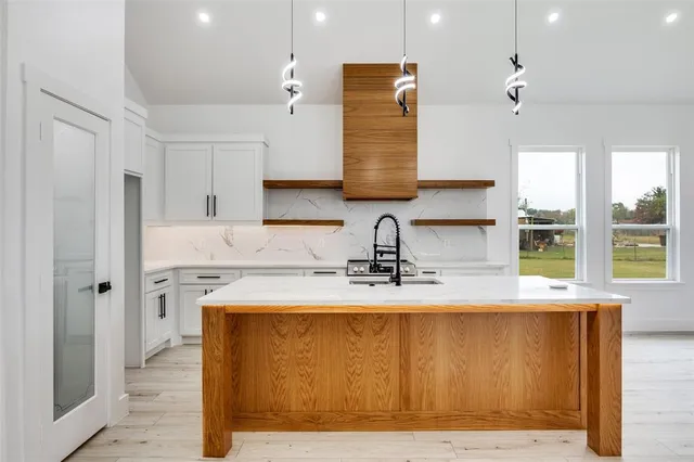 a kitchen with granite countertop a sink cabinets appliances and a counter top space