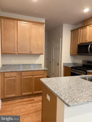 a kitchen with granite countertop a sink stove and microwave
