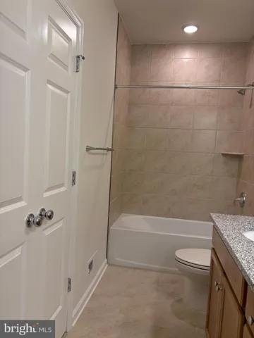 a view of an empty room with closet and entryway