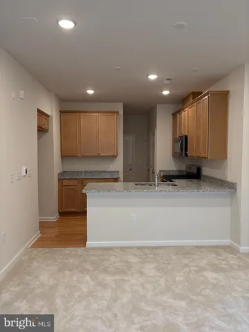 a view of a kitchen with kitchen island sink and refrigerator