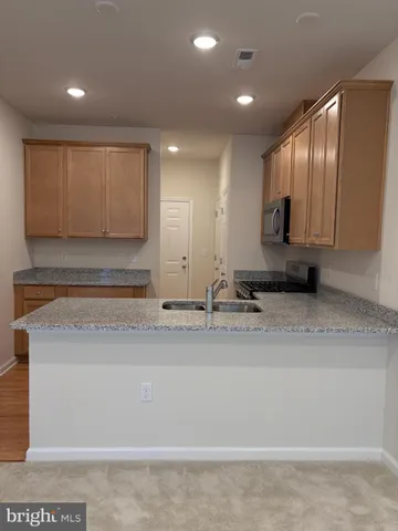 a kitchen with stainless steel appliances granite countertop a sink stove and cabinets