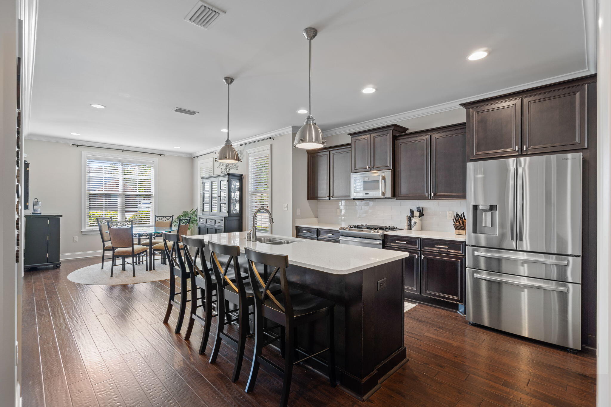 32 Derby Downs Circle Niceville, FL 32578 - Photo 13 of 62 a kitchen with stainless steel appliances granite countertop a stove a refrigerator a kitchen island a dining table and chairs with wooden floor