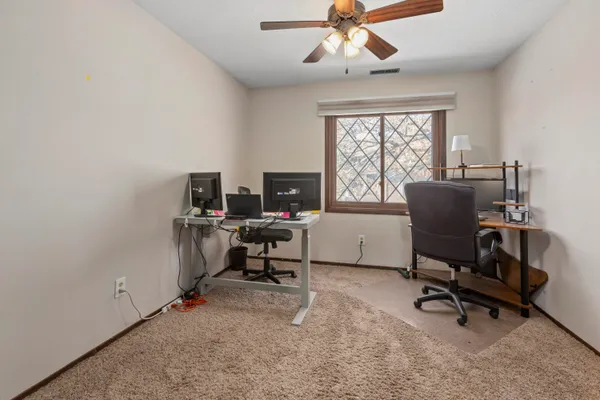 a view of a workspace with furniture and a window