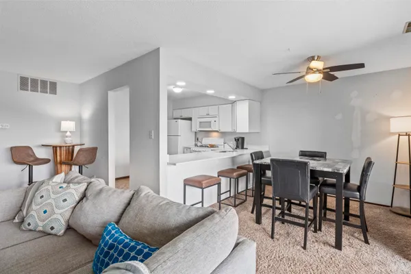 a living room with furniture a dining table and chairs with kitchen view