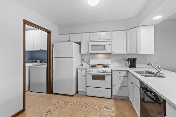 a kitchen with a refrigerator sink stove and white cabinets