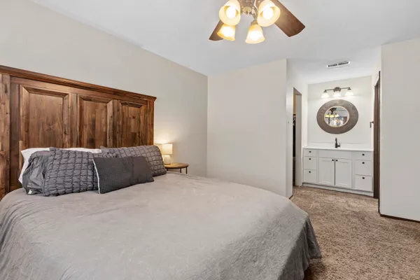 a bedroom with a large bed and a chandelier