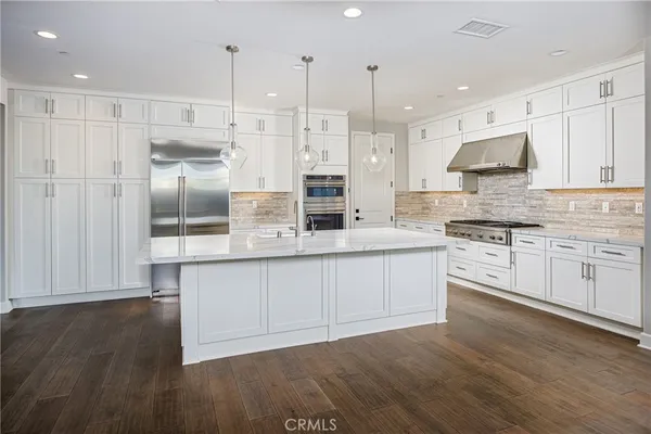 a kitchen with stainless steel appliances granite countertop a stove a sink and white cabinets
