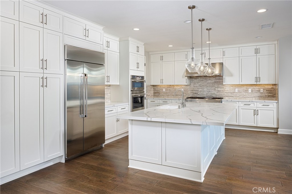2017 Picasso Santa Ana, CA 92704 - Photo 4 of 31 a kitchen with stainless steel appliances granite countertop a sink a refrigerator and white cabinets