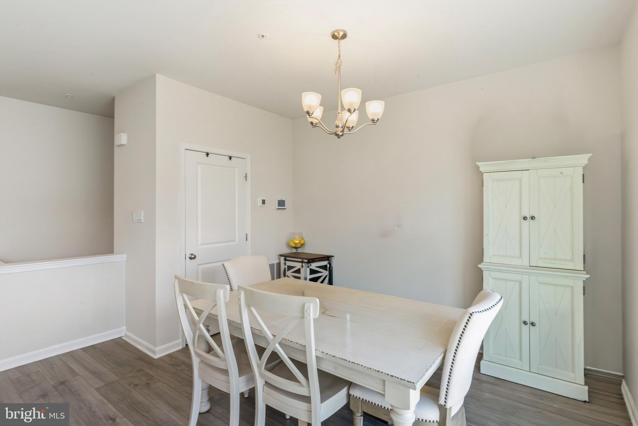 870 Amity Street Frederick, MD 21701 - Photo 13 of 56 a view of a dining room with furniture a chandelier and wooden floor