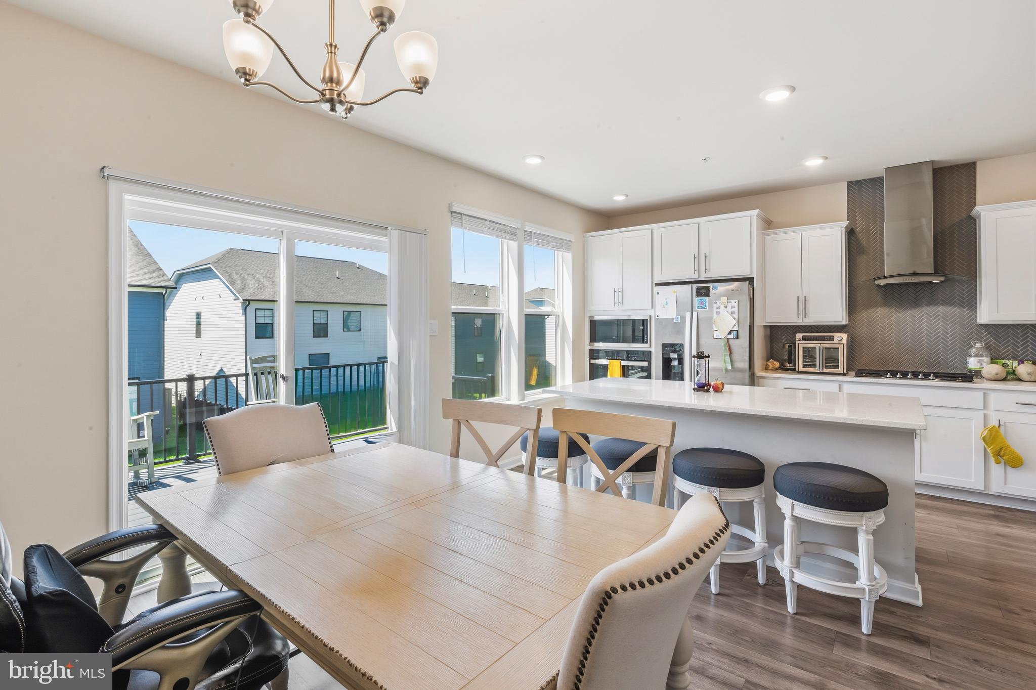 870 Amity Street Frederick, MD 21701 - Photo 15 of 56 a kitchen with a dining table chairs and white appliances