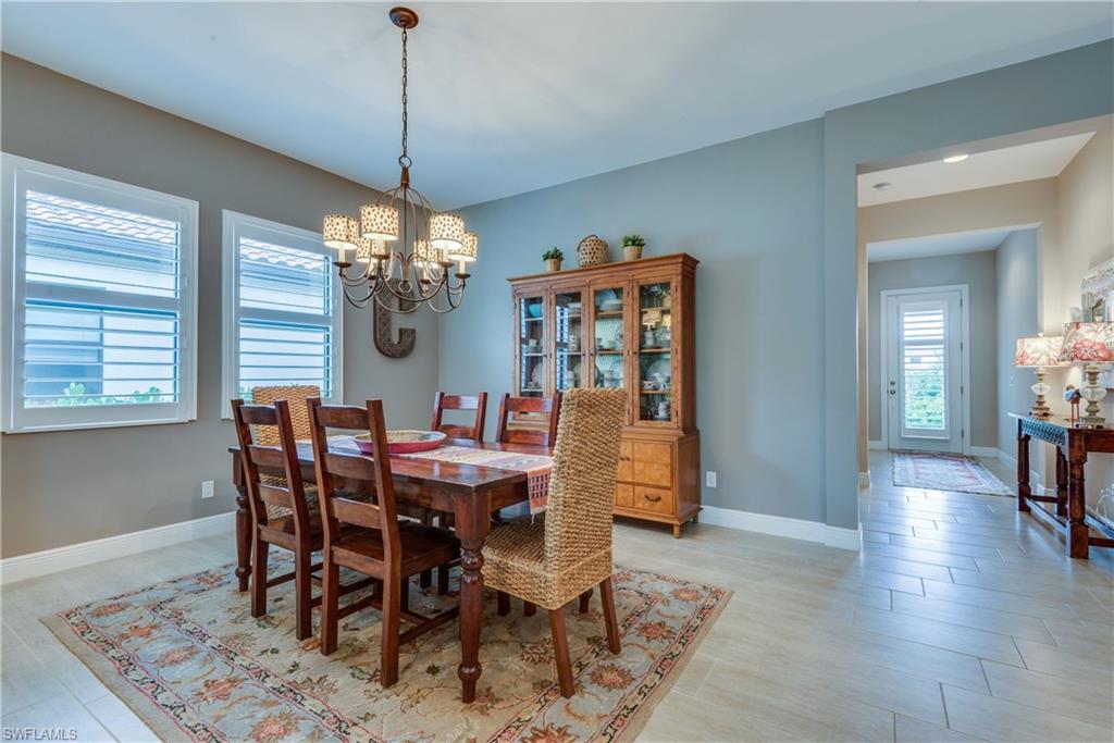 4068 Raffia Drive Naples, FL 34119 - Photo 5 of 25 The staggered, plank-style tiles extend from the foyer throughout all the main living areas. (Lamp shades on dining room chandelier do not convey).