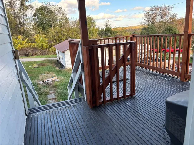 a view of balcony with wooden floor and fence