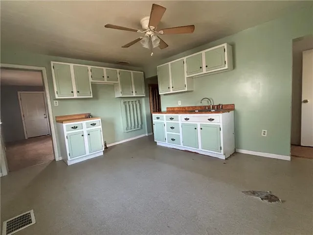 a view of a kitchen with cabinets wooden floor and window