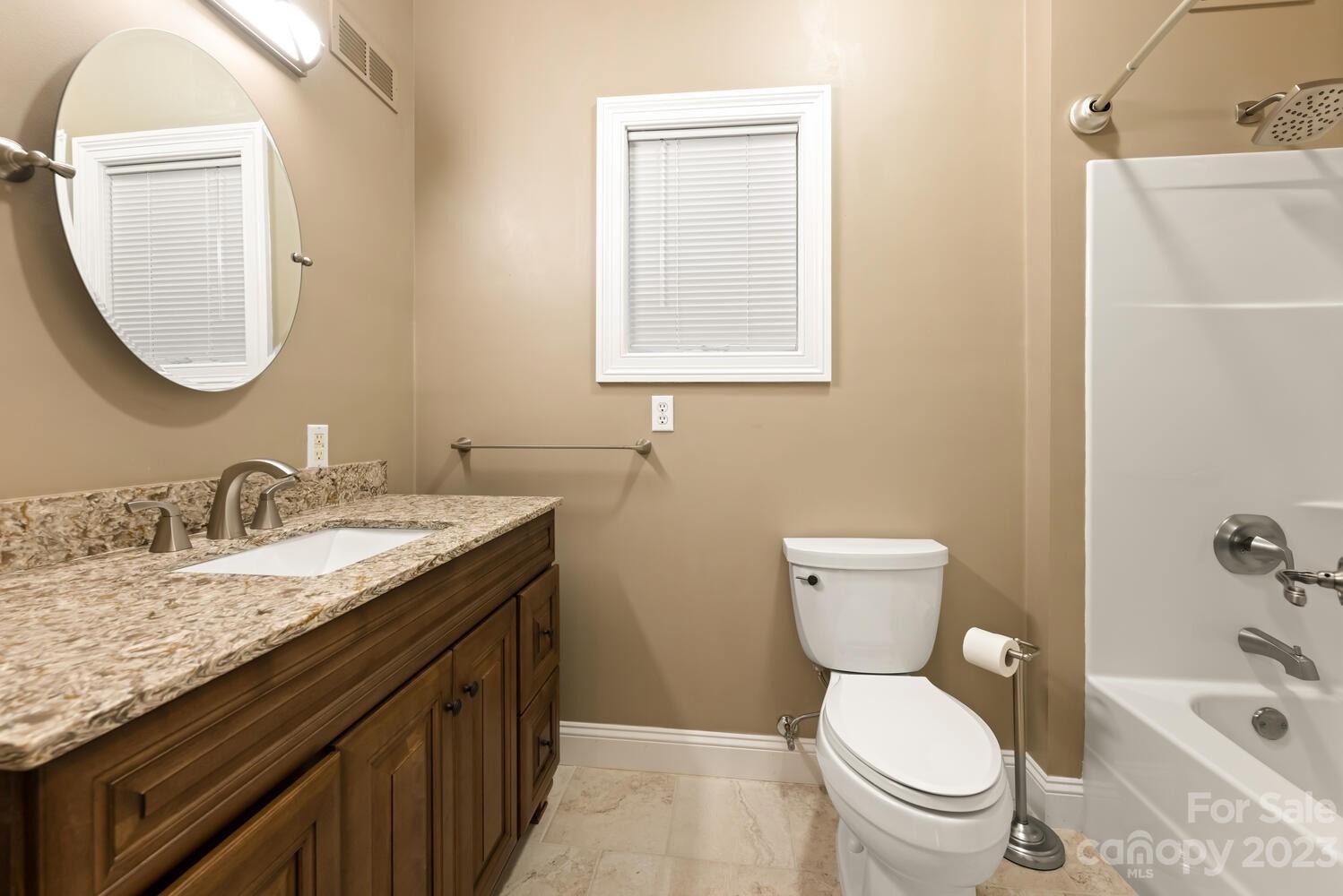 42 Country Club Road Mills River, NC 28759 - Photo 27 of 48 a bathroom with a granite countertop toilet a sink and a mirror