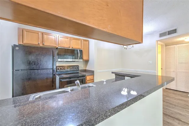 a bathroom with a granite countertop sink a toilet and shower