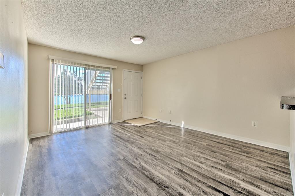 308 Lake Parsons Green, Unit 106 Brandon, FL 33511 - Photo 8 of 26 wooden floor in an empty room with a window