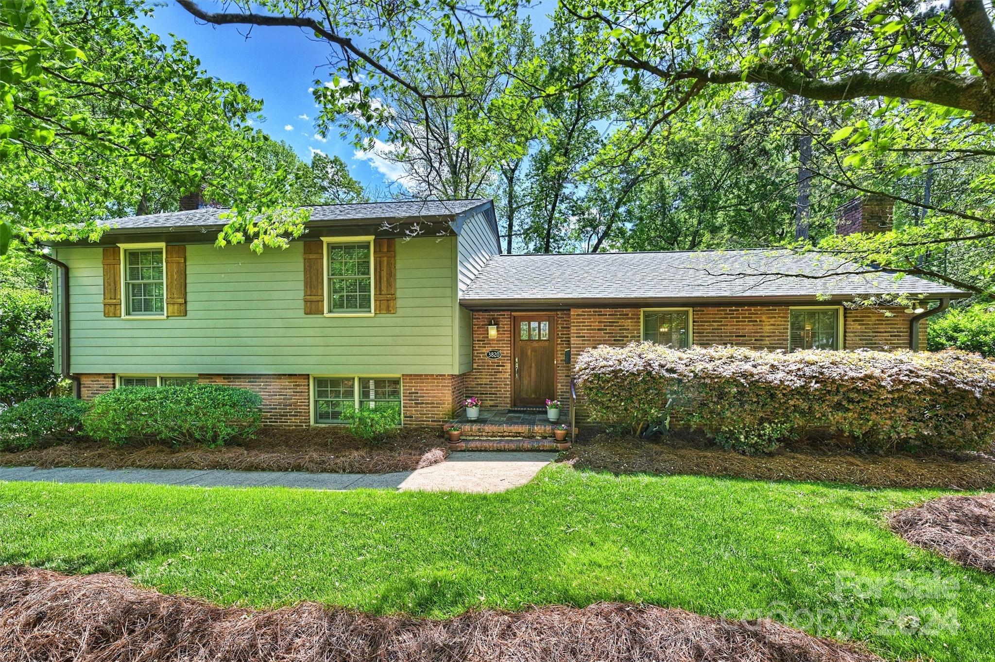 a front view of a house with a yard and potted plants
