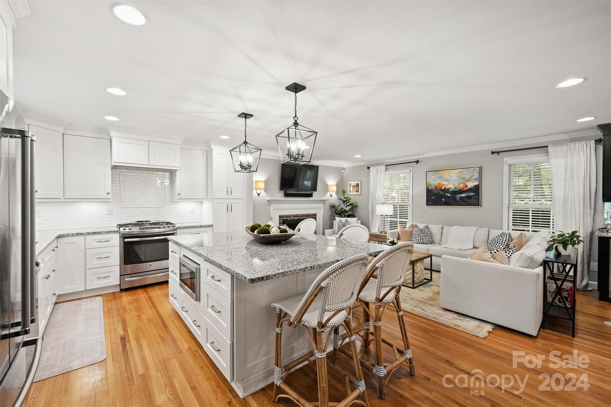 3820 Sulkirk Road Charlotte, NC 28210 - Photo 16 of 48 a kitchen with stainless steel appliances granite countertop a stove top oven a refrigerator a kitchen island a couches and couches with wooden floor