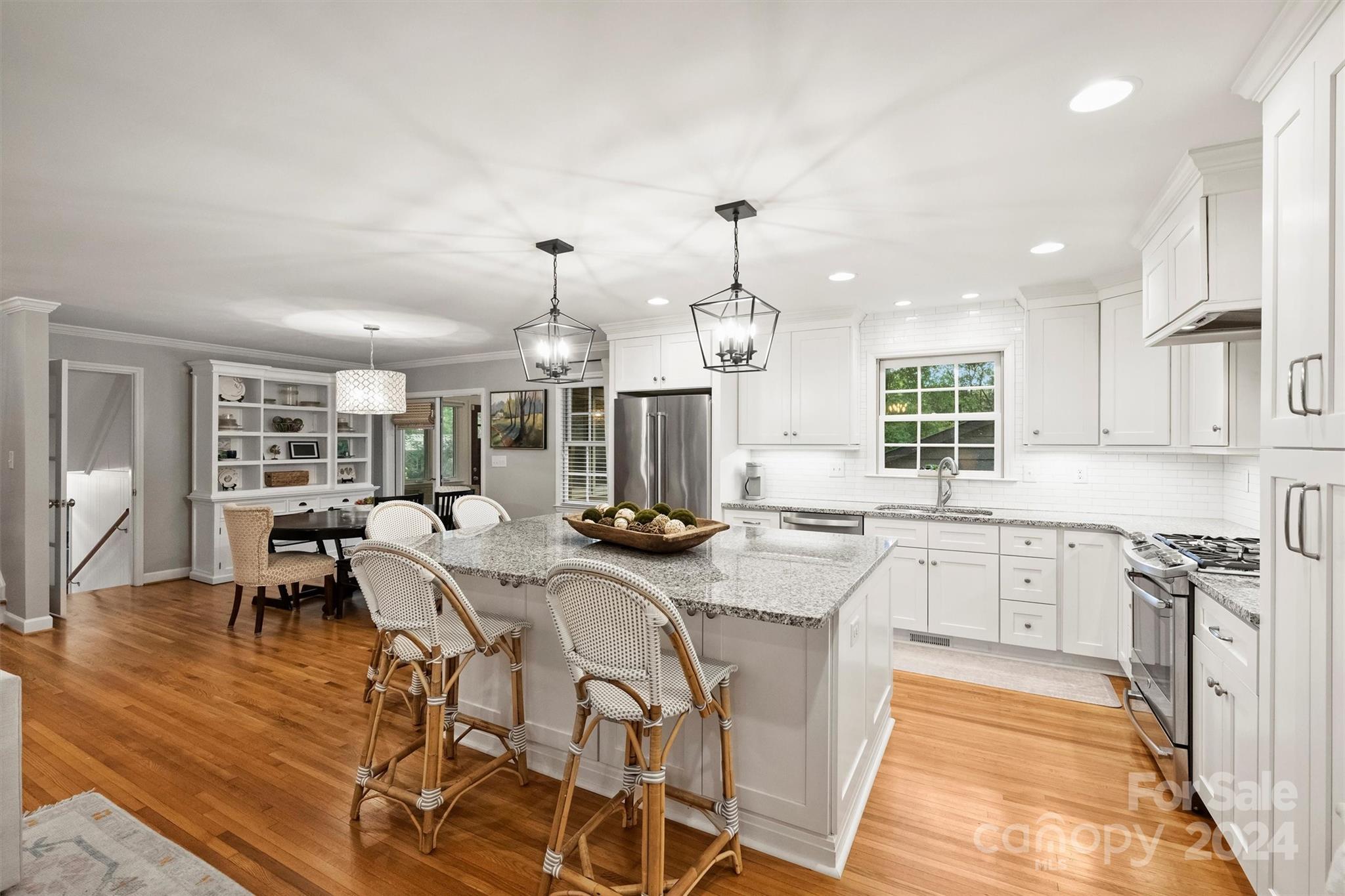 3820 Sulkirk Road Charlotte, NC 28210 - Photo 18 of 48 a kitchen with stainless steel appliances granite countertop a stove a sink dishwasher a dining table and chairs with wooden floor