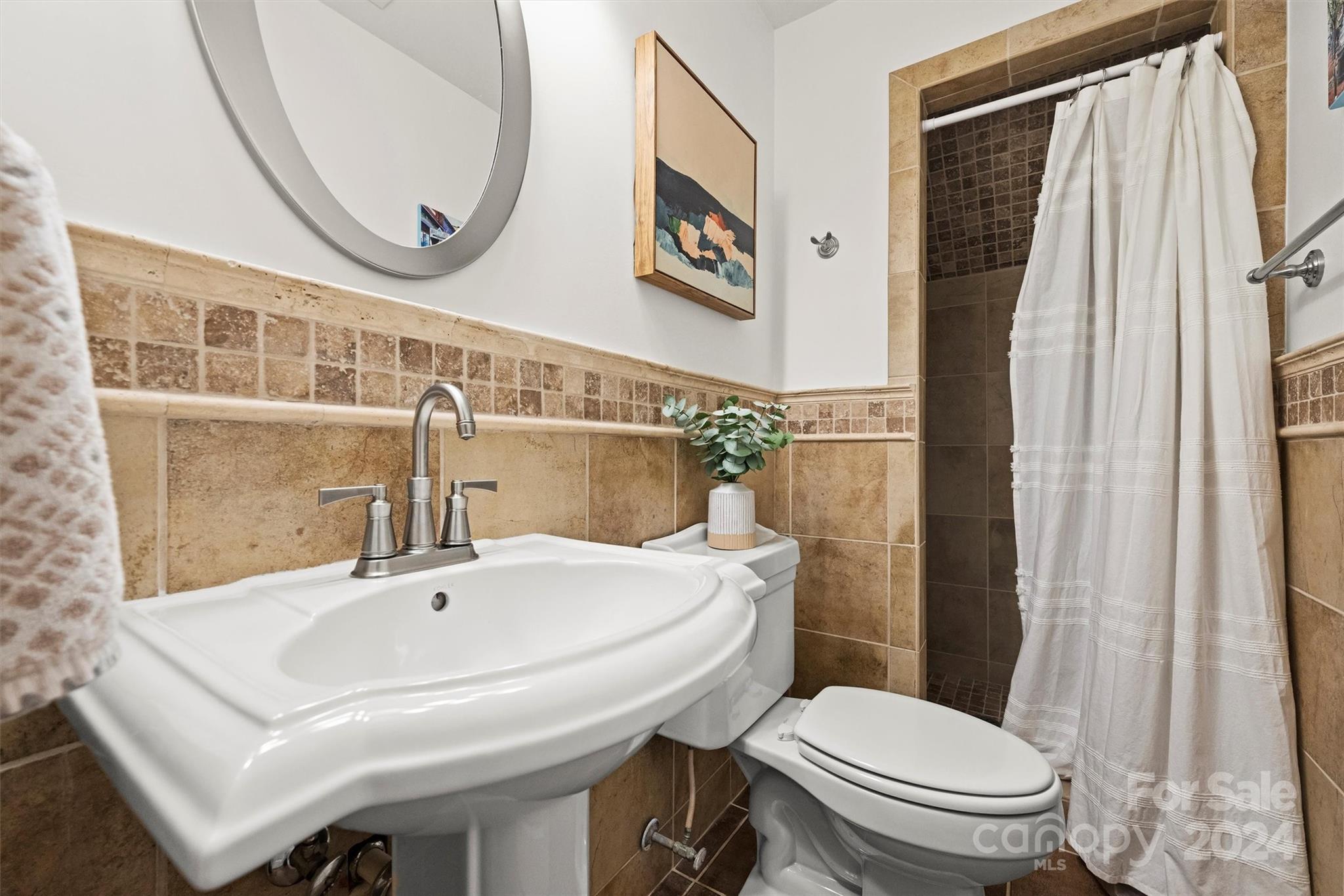 3820 Sulkirk Road Charlotte, NC 28210 - Photo 26 of 48 a bathroom with a sink a toilet and a mirror