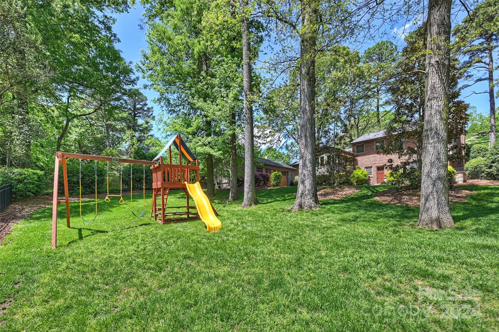 3820 Sulkirk Road Charlotte, NC 28210 - Photo 42 of 48 a view of a backyard with a slide trees and wooden fence