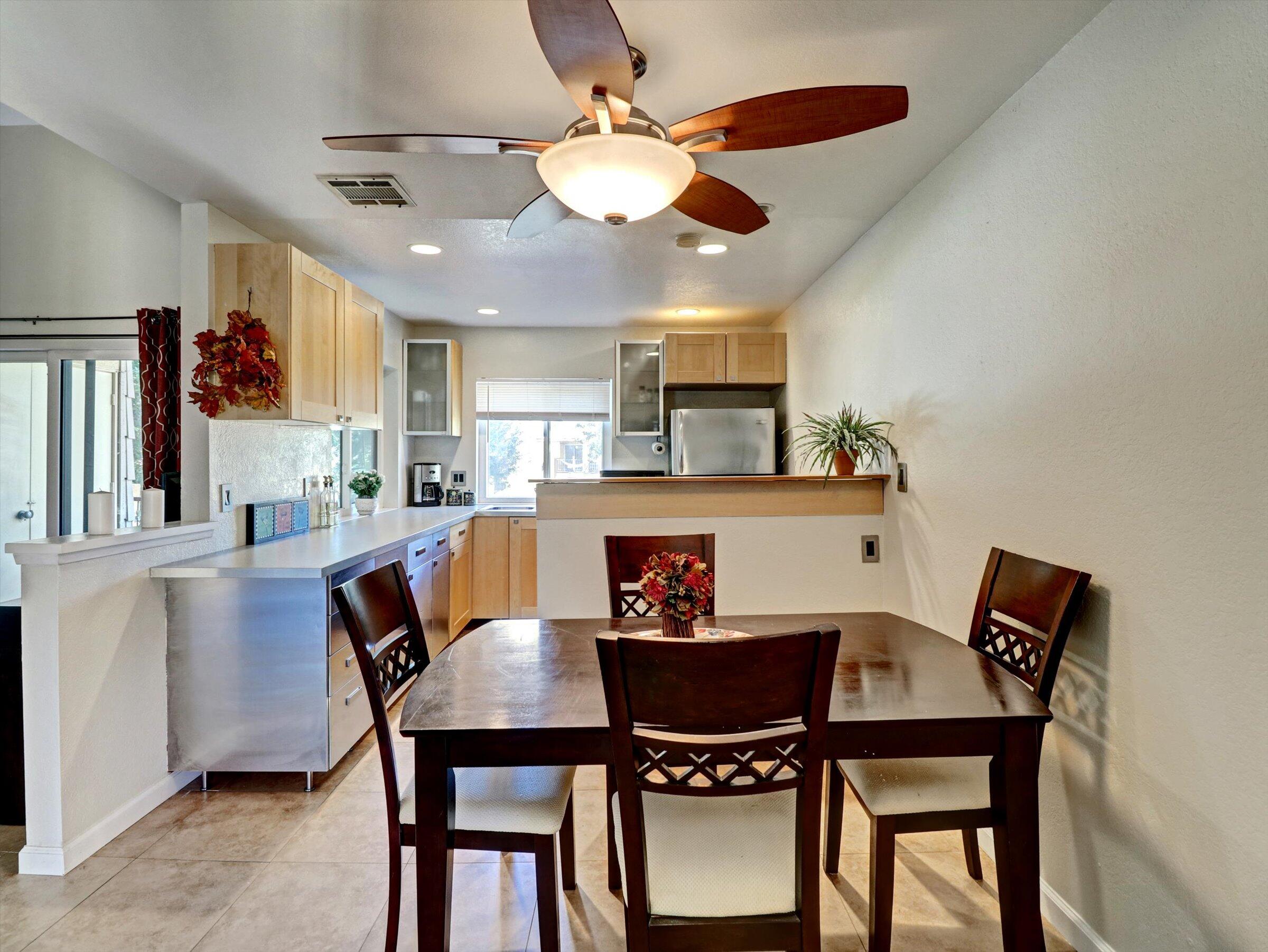 a view of a dining room with furniture and a chandelier fan