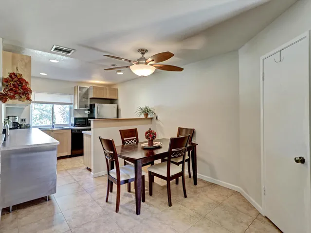 a view of a dining room with furniture and a chandelier fan