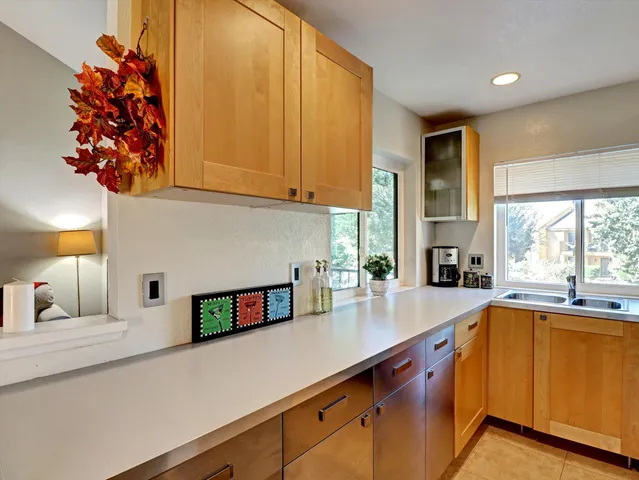 a kitchen with stainless steel appliances a sink dishwasher and a microwave with wooden floor