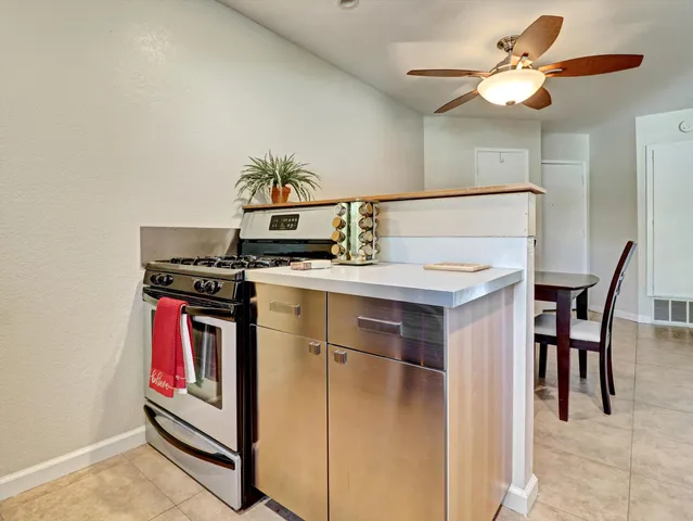 a kitchen with stainless steel appliances granite countertop a stove a chimney a sink and cabinets