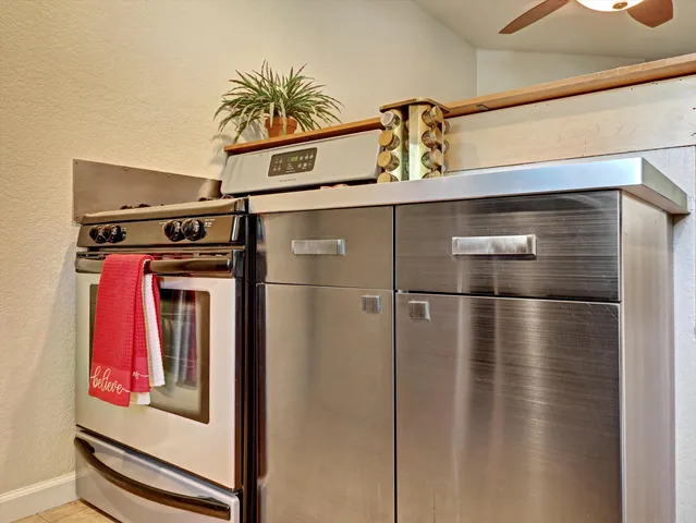a view of a refrigerator in kitchen and an empty room