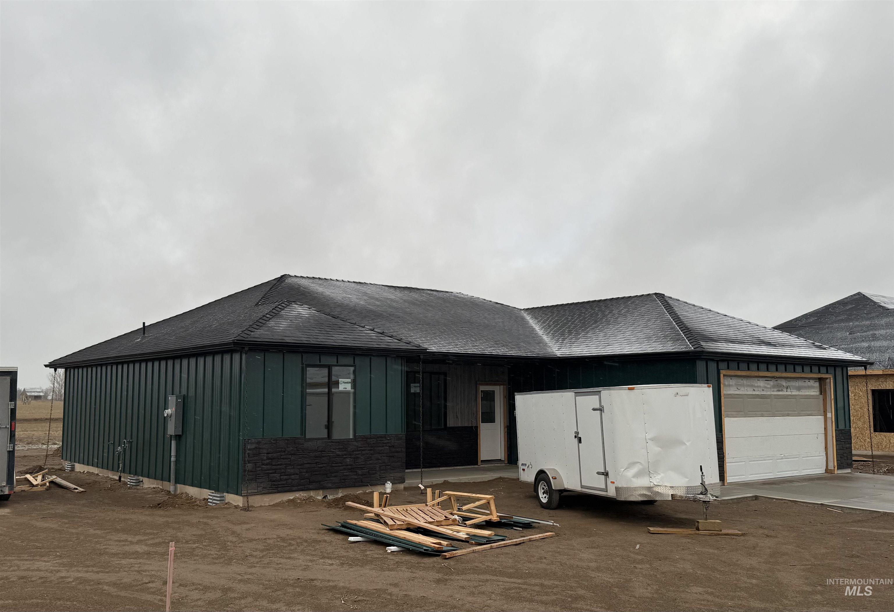 1019 Moss Avenue Rupert, ID 83350 - Photo 1 of 1 View of front of home with board and batten siding, a garage, roof with shingles, and driveway