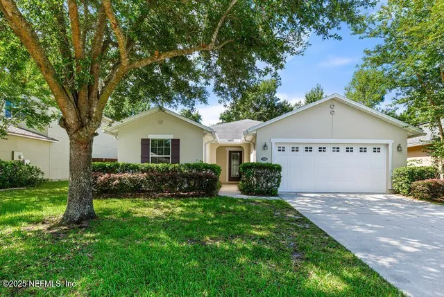 a view of front a house with a yard and potted plants