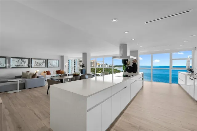 a large white kitchen with a large window and couch