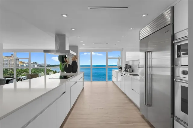 a large kitchen with kitchen island a large counter top stainless steel appliances and cabinets