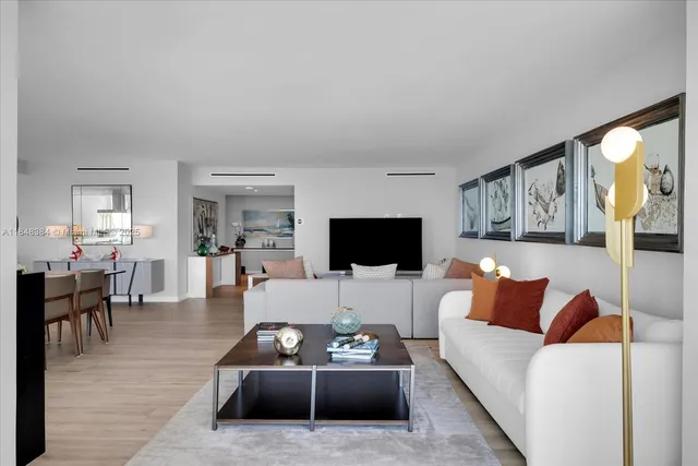 a living room with furniture a flat screen tv and a large window