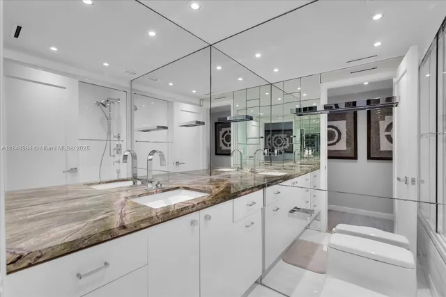 a bathroom with a granite countertop sink mirror and shower