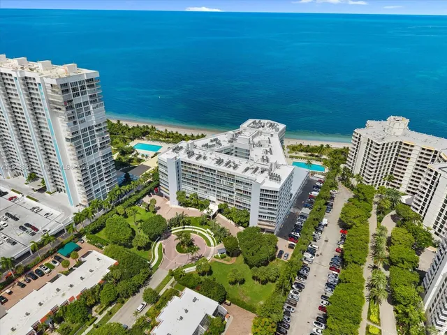 a view of a swimming pool with a lawn chairs and potted plants