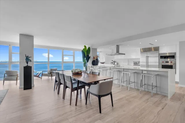 a kitchen with kitchen island a dining table and chairs