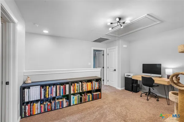 a view of a livingroom with a bookshelf and a window