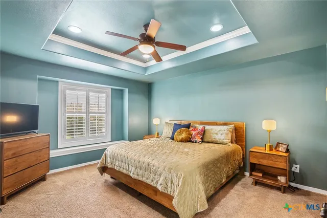 a bedroom with a bed and a flat tv screen on dresser