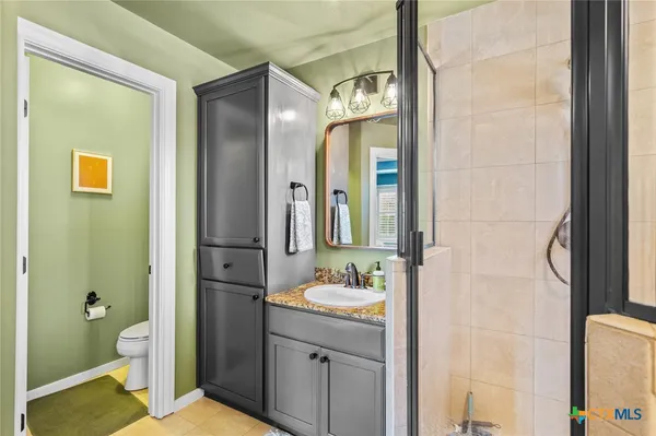 a bathroom with a sink a toilet and shower