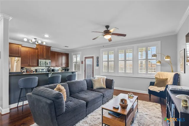 a living room with furniture a large window and a chandelier