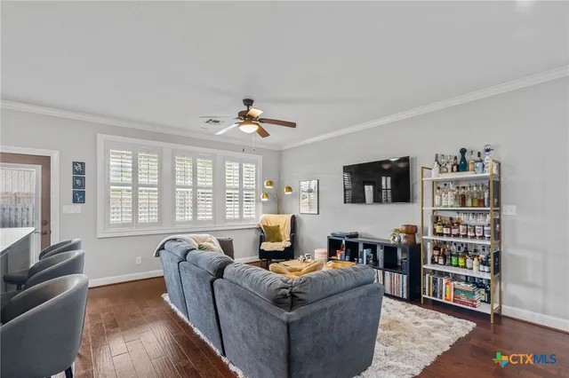 a living room with furniture a flat screen tv and a window