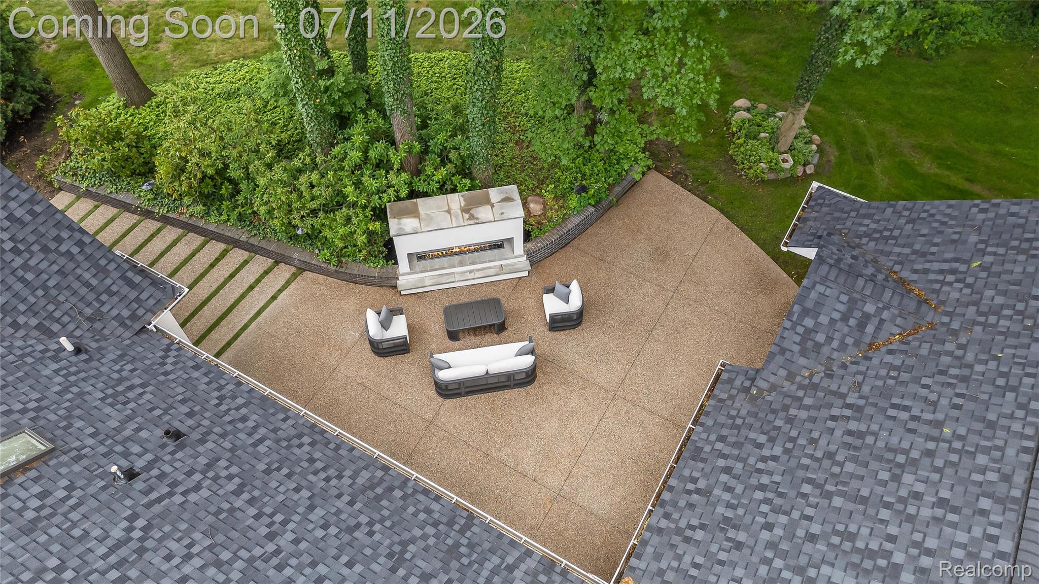 4154 Nearbrook Road Bloomfield Hills, MI 48302 - Photo 45 of 47 Expansive outdoor living area featuring a stone fireplace, a large patio with decorative paving, and an adjacent landscaped garden with mature trees