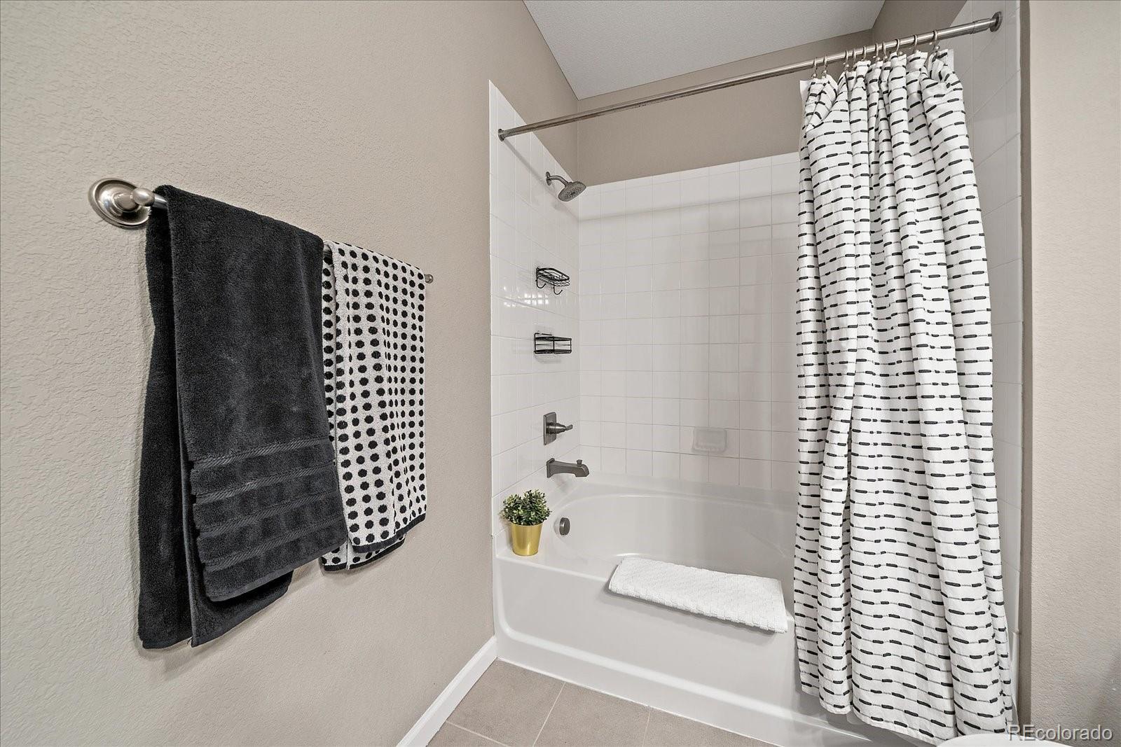 4474 Copeland Circle, Unit 203 Highlands Ranch, CO 80126 - Photo 18 of 33 a bathroom with a bathtub and shower